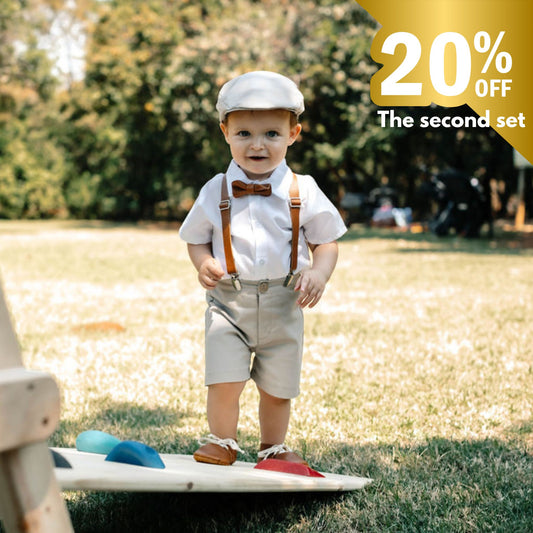 Baby boy in formal outfit standing outdoors with promotional text overlay
