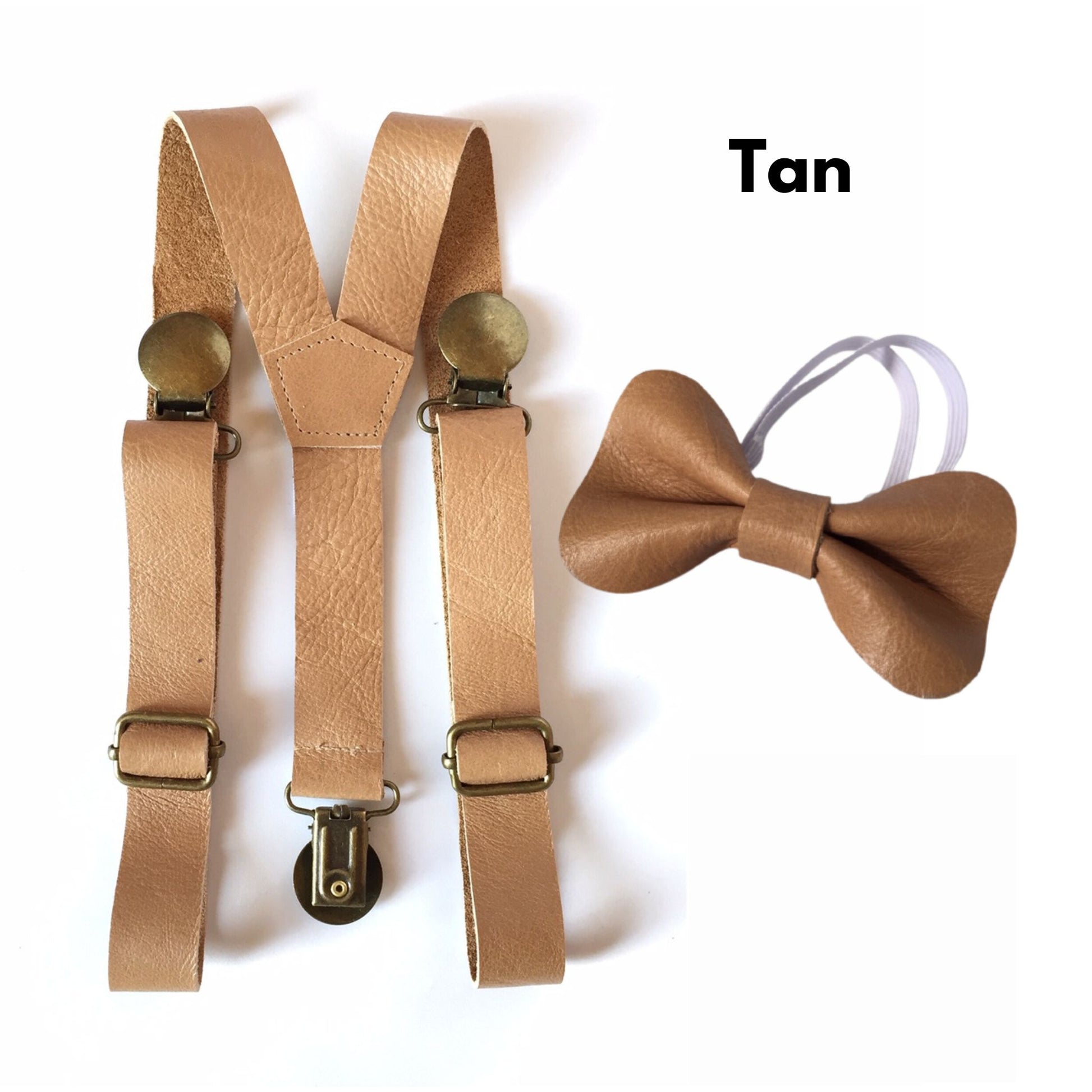 Tan baby leather suspenders and bow tie set on a white background.