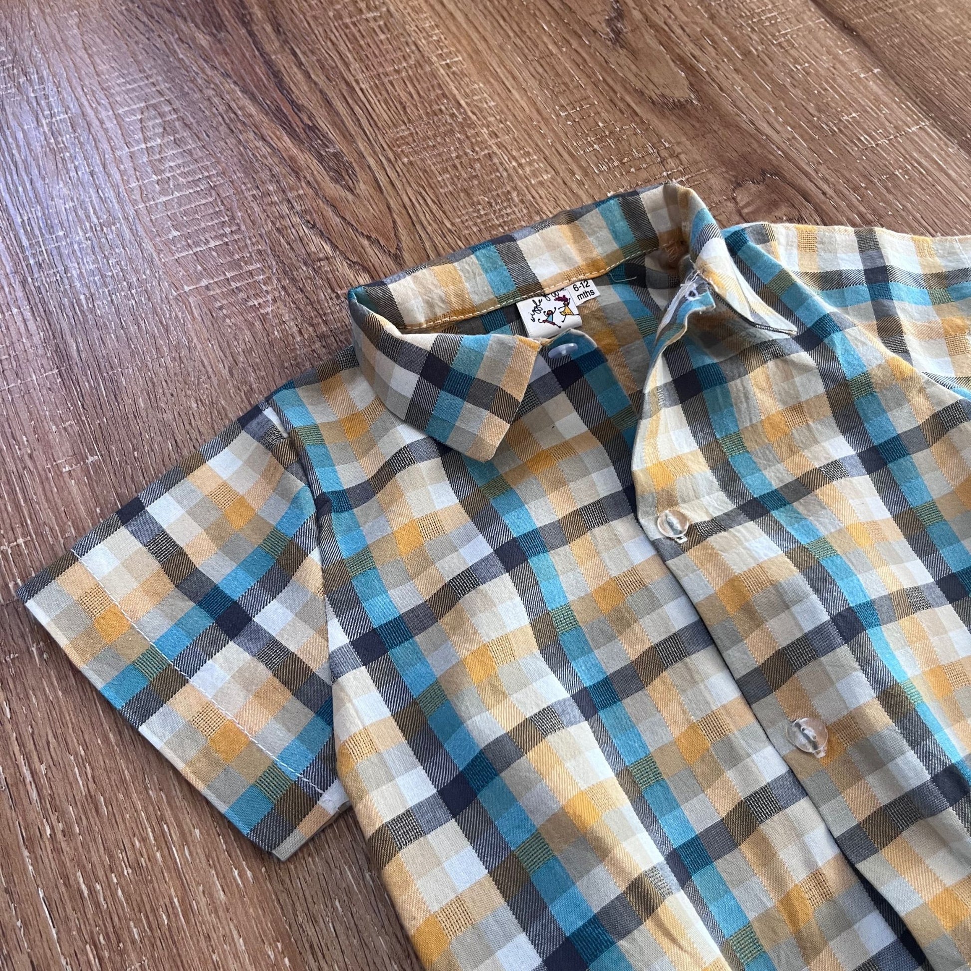 Baby boy check shirt on a wooden surface