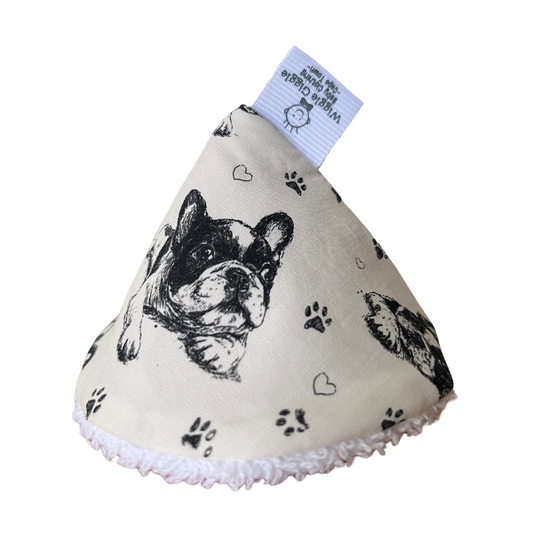 A cone-shaped pee pee teepee made of cream-colored fabric printed with black French Bulldog illustrations, paw prints, and hearts.