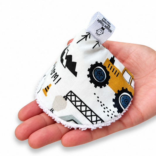 A construction-themed print pee pee teepee, held in a person's hand against a plain white background.
