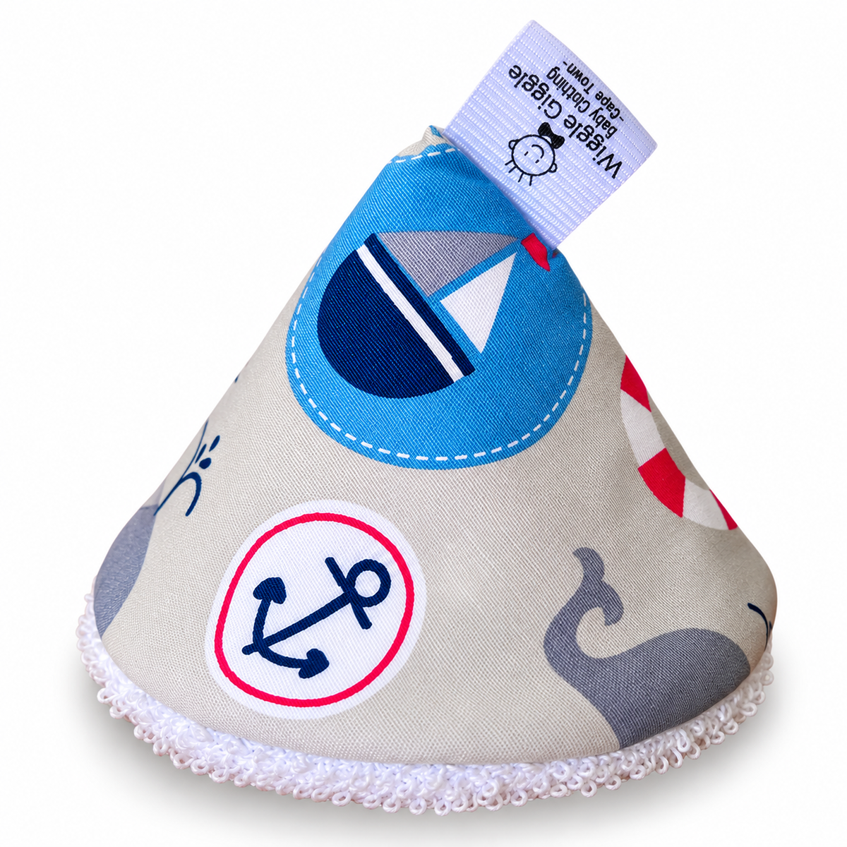 Pee pee teepee with a nautical theme, featuring a light beige fabric body with a sailboat, whale tail, and anchor print with a fabric tag that reads 'Wibble Giggle Baby Clothing'.