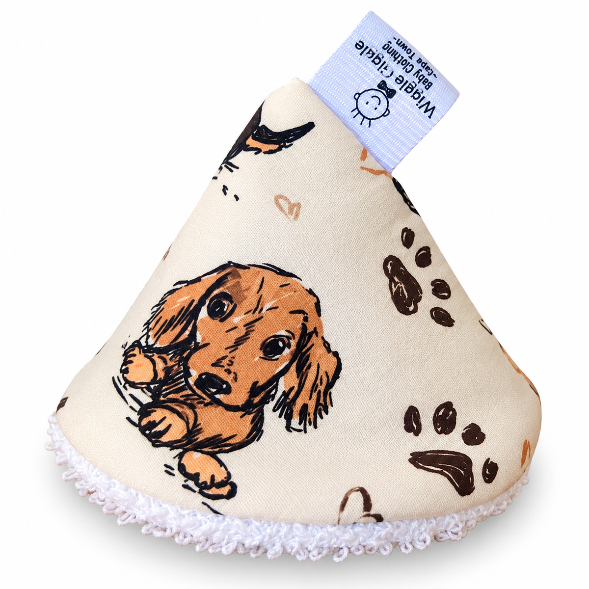 Cream coloured pee pee teepee with dachshund design and paw prints on a white background